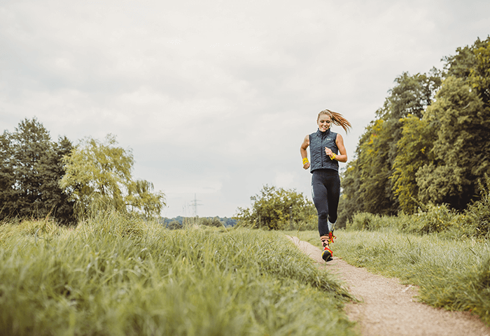Frau joggt auf Feldweg