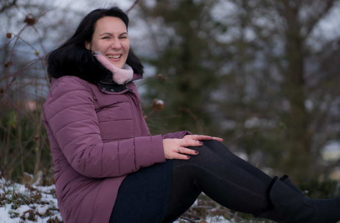 Nicole O. sitzt mit Winterjacke im Freien und berichtet von ihren positiven Almased-Erfahrungen