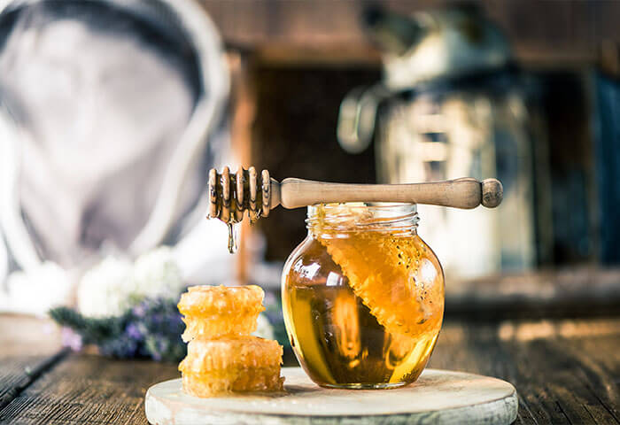 enzymreicher Bienenhonig in einem Glas mit Honiglöffel