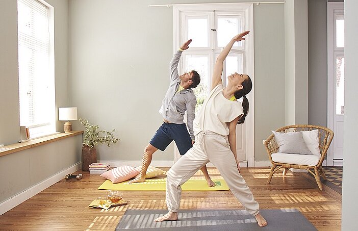 Mann und Frau machen Yoga und benötigen dafür Proteinquellen mit einer hohen biologischen Wertigkeit.