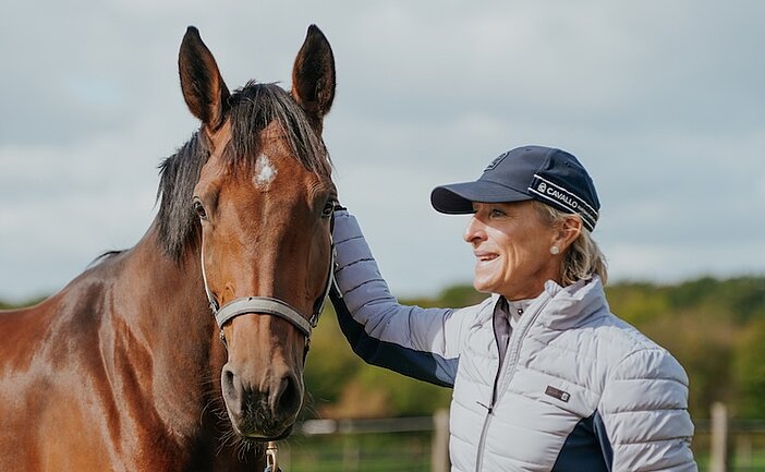 Frau mit Pferd auf Wiese