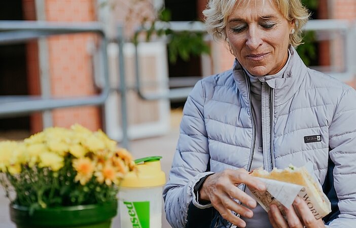 Frau mit Sandwich im Garten