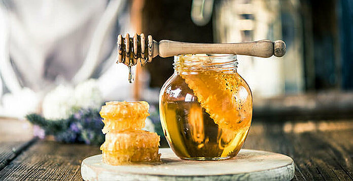 enzymreicher Bienenhonig im Glas auf einem Holzbrett, ein Bestandteil von Almased für tolle Abnehm-Erfahrungen