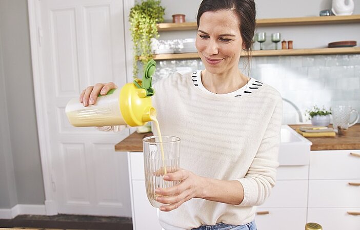 Frau füllt Almased in Glas