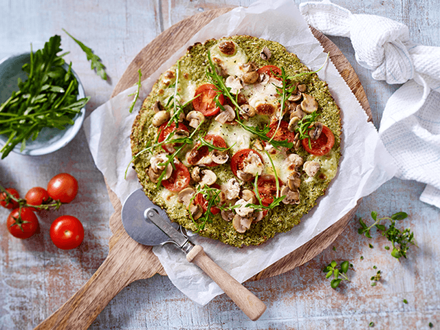 Pizza mit Tomaten, Champignons und Rucola