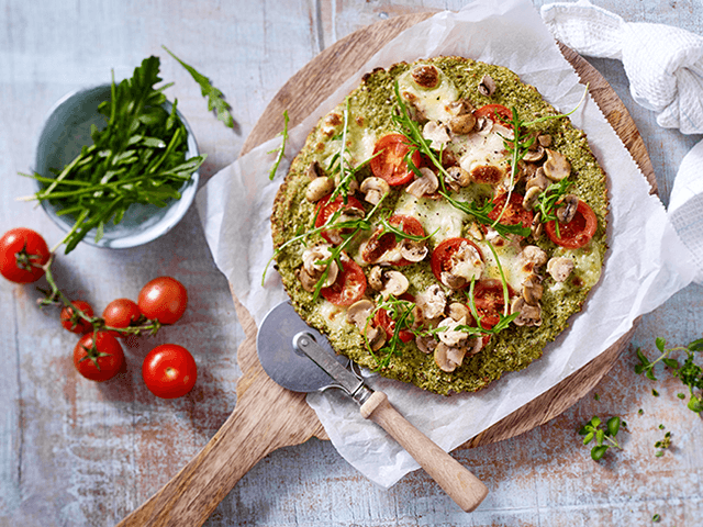 Pizza mit Tomaten, Champignons und Rucola