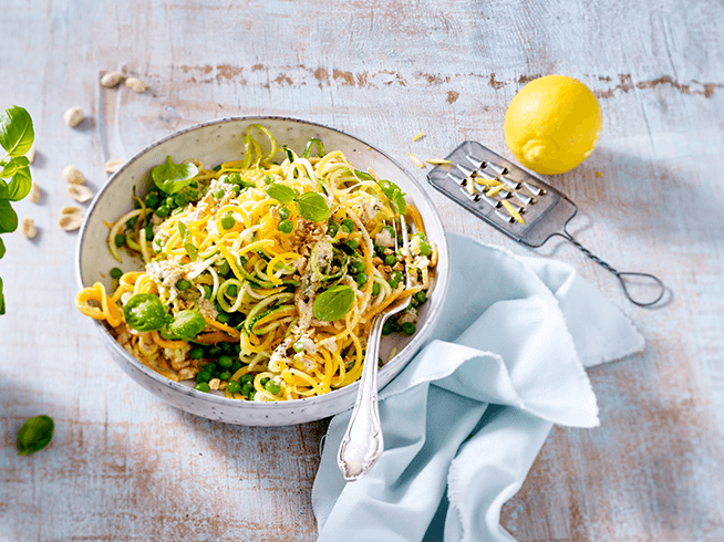 Gemüsespaghetti mit Erbsen und Nusssauce