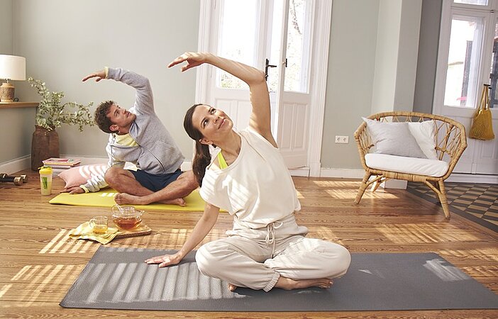 Mann und Frau machen Yoga um Stoffwechsel zu boosten