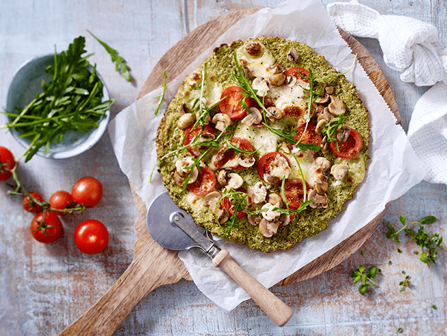 Pizza mit Tomaten, Champignons und Rucola