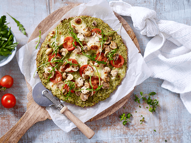 Pizza mit Tomaten, Champignons und Rucola