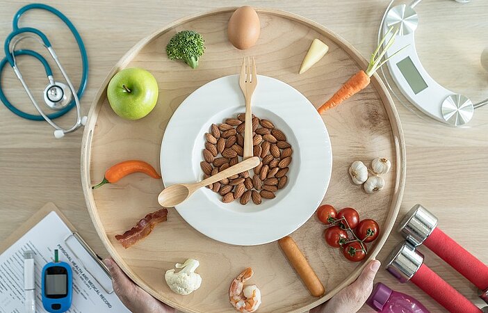 Uhr mit verschiedenen Lebensmitteln anstelle von Zahlen symbolisiert die Regeln des Glukose-Tricks